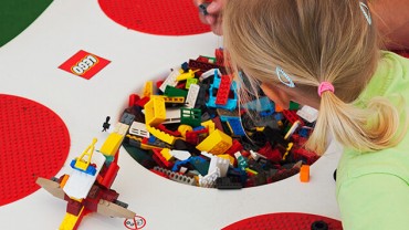 Wesołe dziecko układa klocki w Ogródku budowlanym LEGO Łebskie Klocki