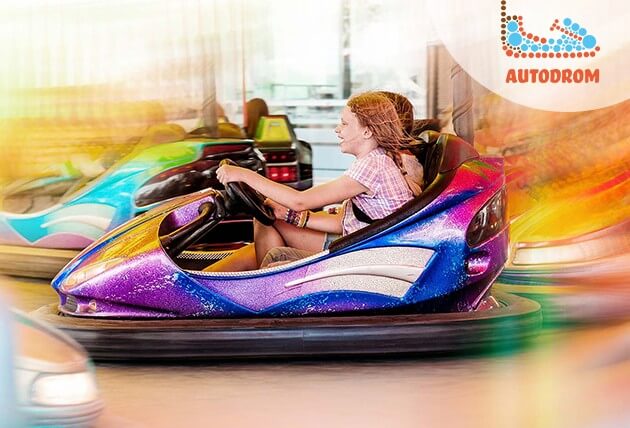 Radosne dzieci jeżdżą na atrakcji "autodrom"