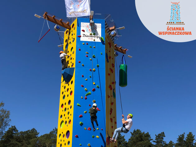 Dzieci wspinają sie na niebiesko żółtą ściankę wspinaczkową w Discovery Park