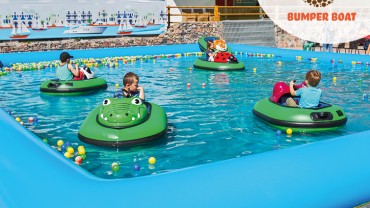 Radosne dzieci pływają na łódeczkach Bumper Boat w basenie wypełnionym wodą i kuleczkami